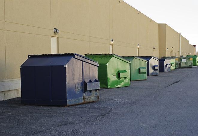 several large trash cans setup for proper construction site cleanup in Acton